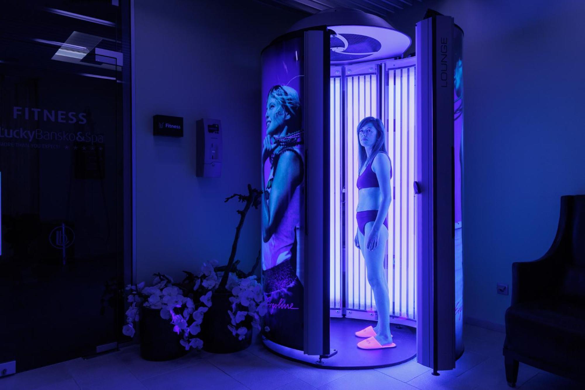 Lucky Bansko Aparthotel Spa & Relax Exterior photo A woman tanning in a solarium